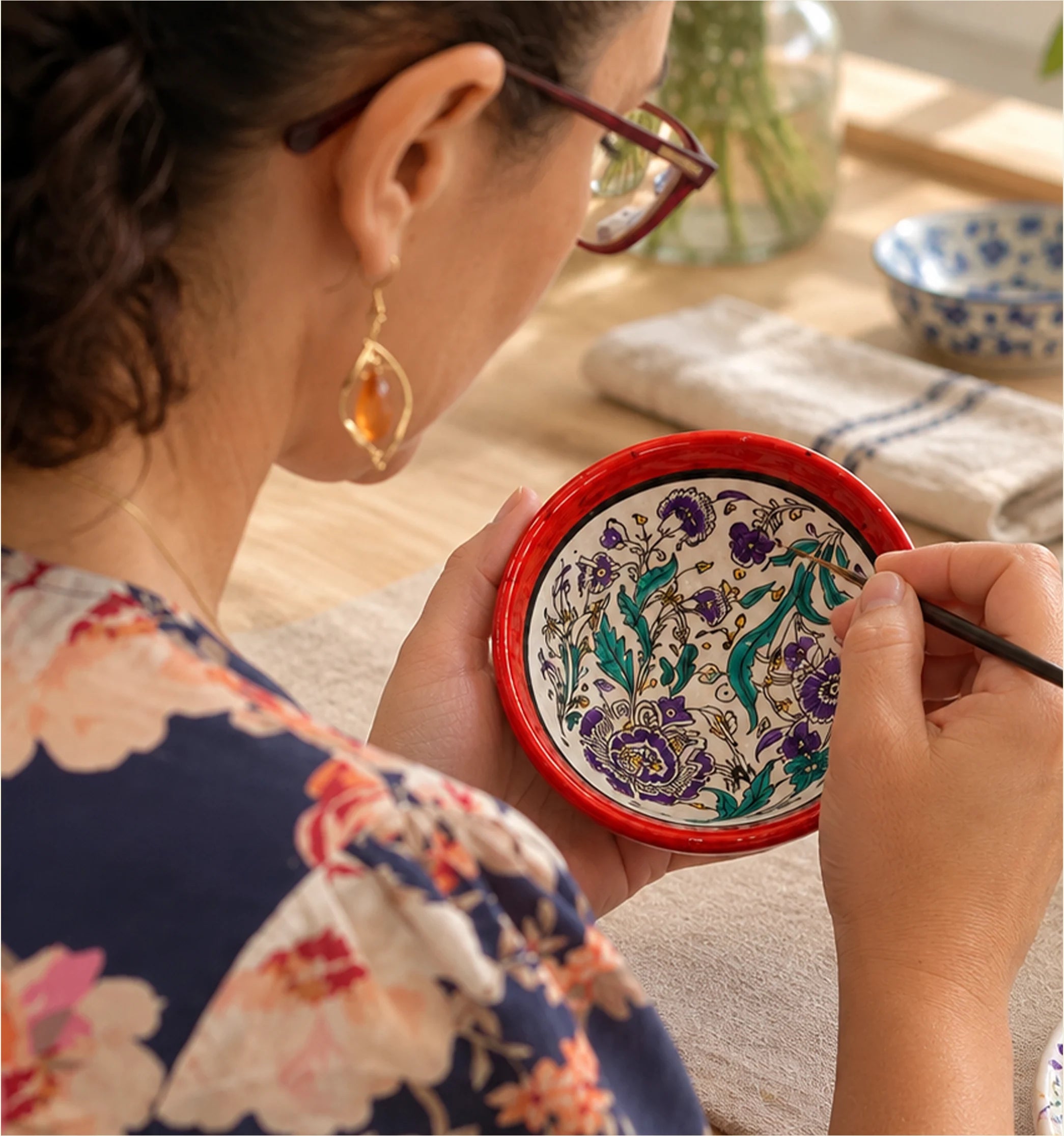 Colourful hand-painted ceramic pieces and painting materials